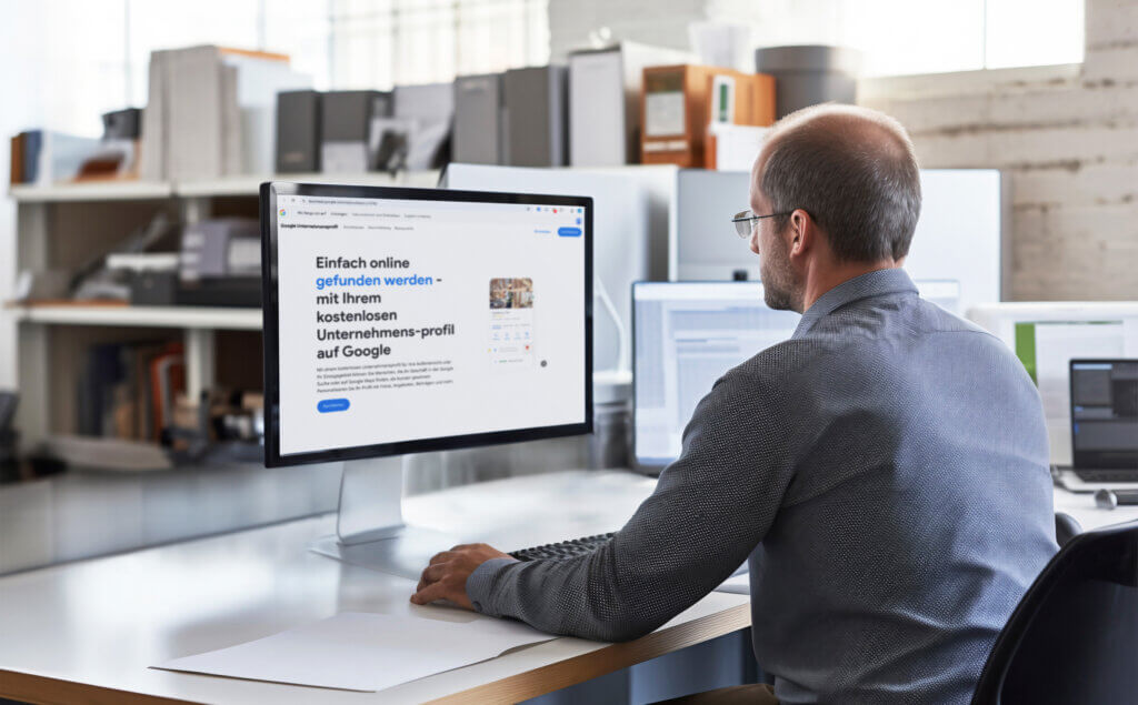 Man sitzt in einem Büro vor einem Bildschirm und hat die Webseite vom Google Unternehmens Profil geöffnet.